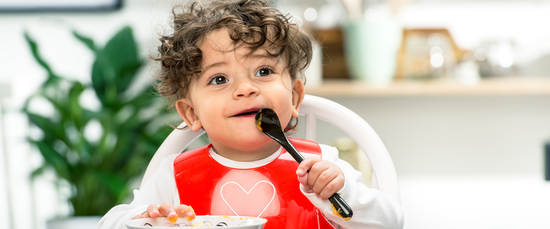 Toddler with red bib eating